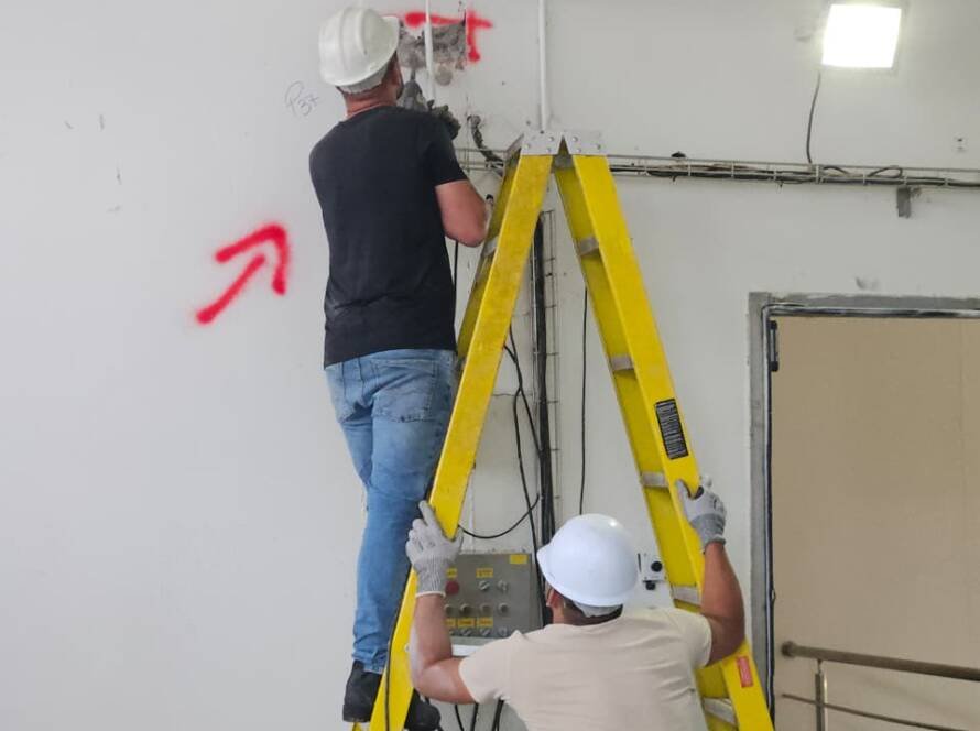 Inspeção técnica em estrutura de concreto deteriorada durante diagnóstico estrutural em complexo industrial.