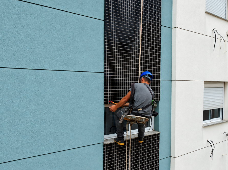 Profissional realizando inspeção por percussão em revestimento cerâmico de fachada de edifício